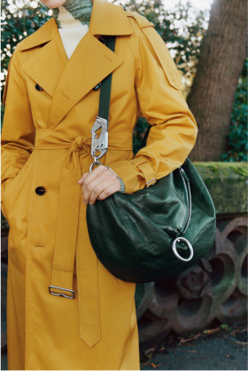 Woman wearing Burberry trench and holding a handbag